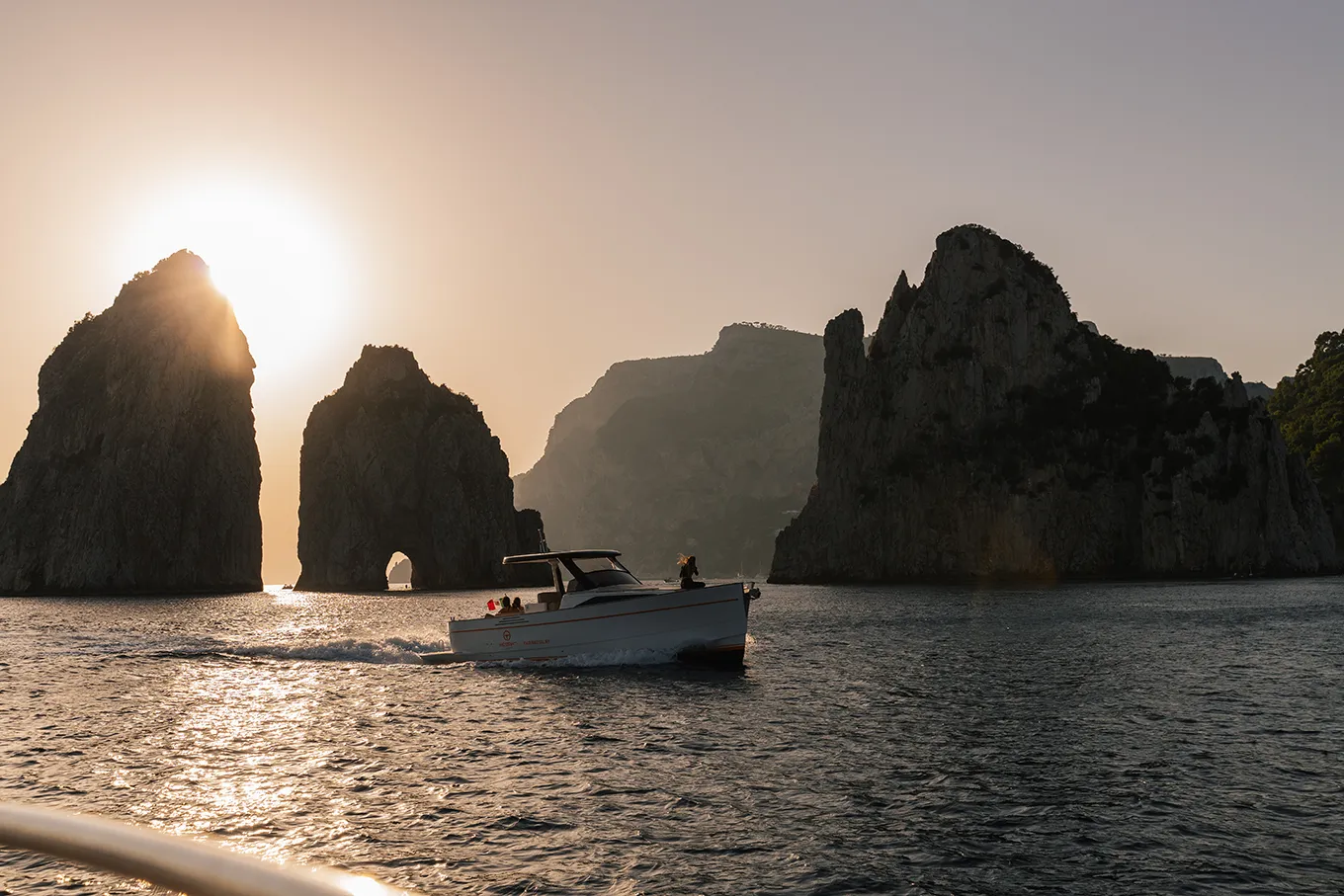 Sunset on a private boat with coastal views of Capri