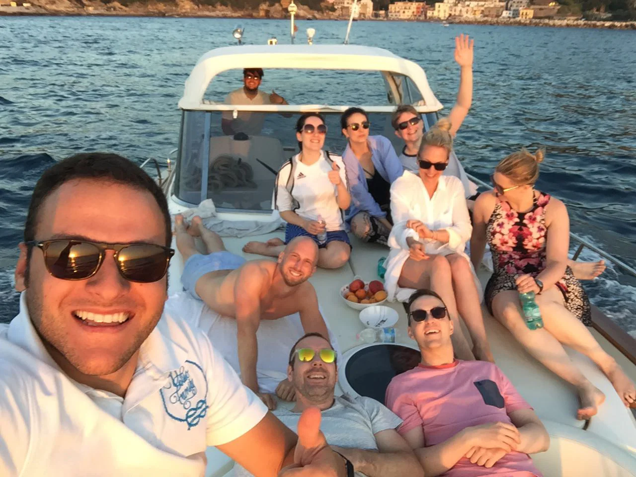 Group of friends exploring Ischia’s coastline on a private boat