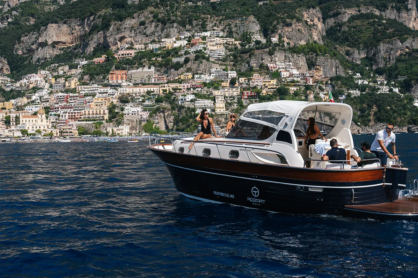 Group of friends relaxing on a Gozzo off the coast of Positano