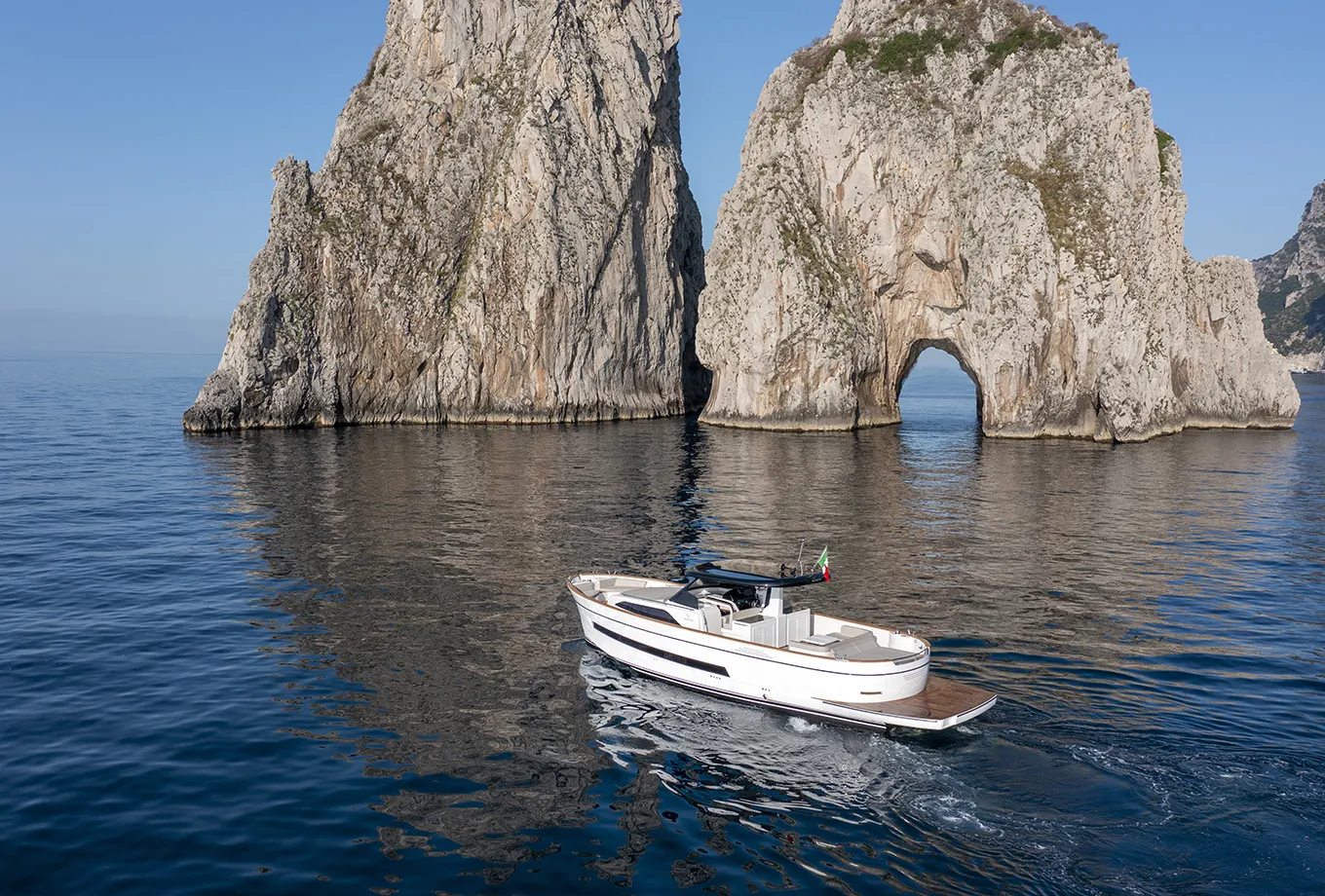 Boat sailing through the crystal-clear sea around Capri, surrounded by stunning scenery